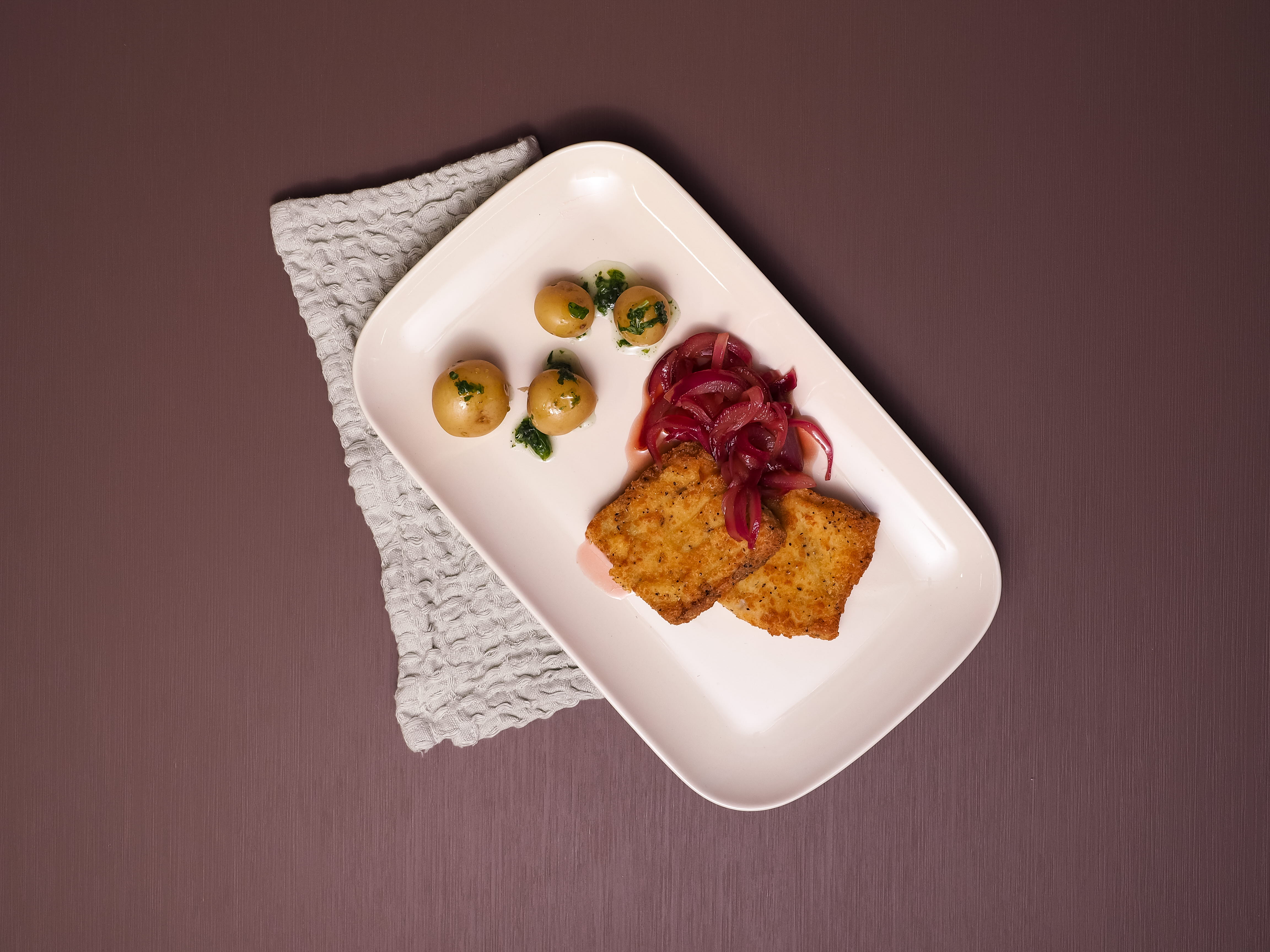 Sprø torsk med rødløkskompott, minipotet og urteolje